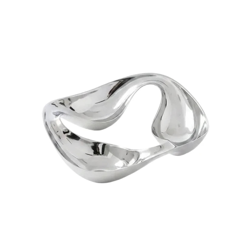 Modern silver two-compartment bowl with almonds on a gray surface